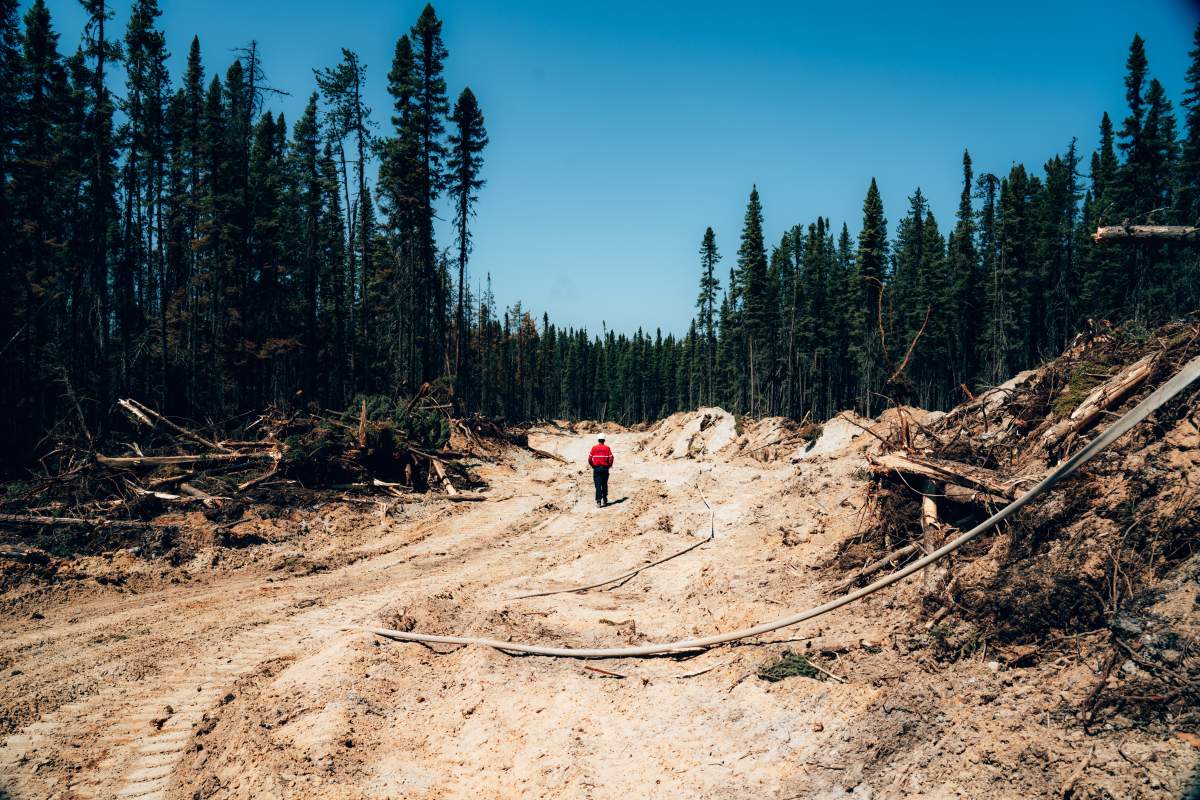 A fire fighter walks down a dirt road near Chapais, in Northern Quebec, on Friday June 2, 2023 in this image provided by the fire prevention agency known as SOPFEU.