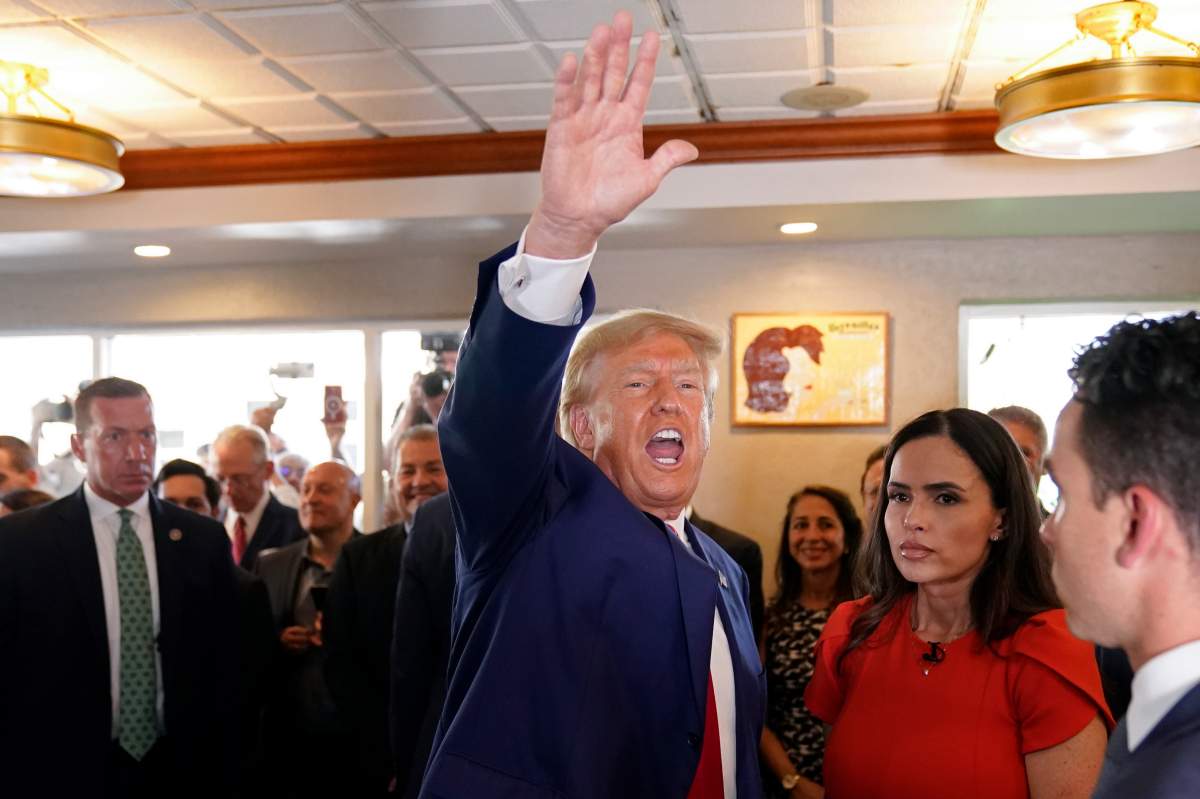 Former President Donald Trump waves to supporters at Versailles restaurant on Tuesday, June 13, 2023, in Miami.