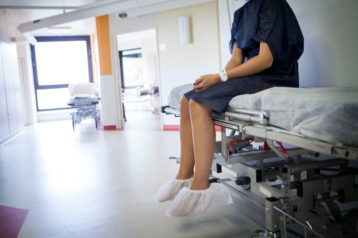 Patient on a stretcher with an identification bracelet in the outpatient surgery department.