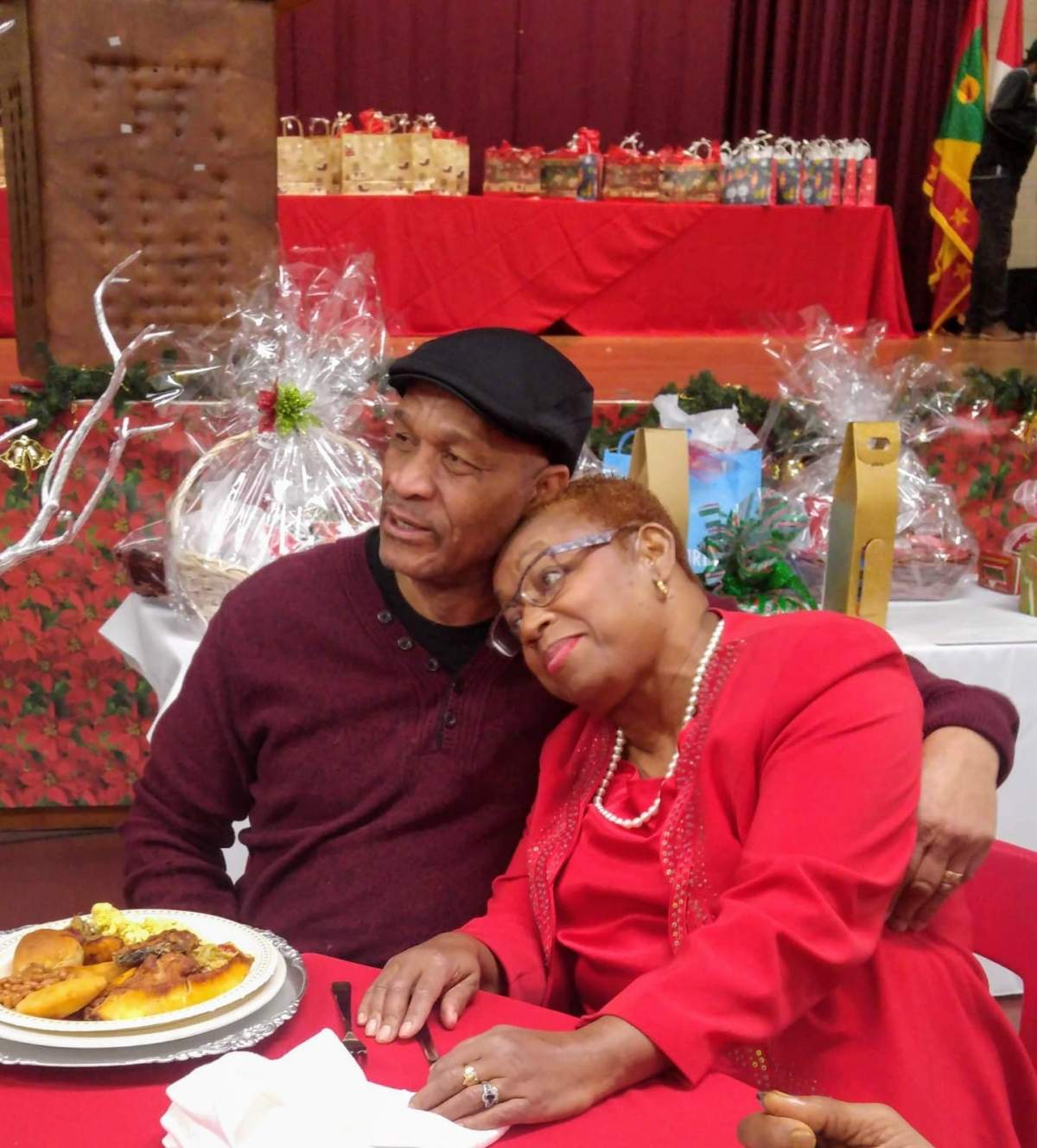 Montreal Community Contact newspaper founder Egbert Gaye, left, hugs longtime friend Gemma Raeburn-Baynes during an event. Raeburn-Baynes said of her friend that his legacy will be the contribution he made to the Black English and Caribbean communities. (Photo: courtesy Gemma Raeburn-Baynes)