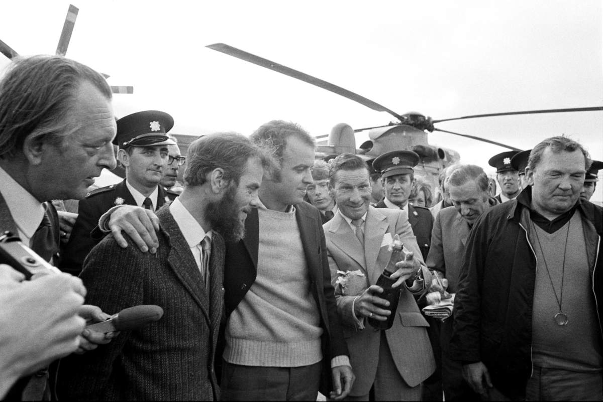 Roger Mallinson (left), 35, and Roger Chapman, 28, watch as a bottle of champagne is opened after their rescue from the Atlantic seabed, where they had been trapped for over 70 hours in the damaged miniature submarine, Pisces III.
