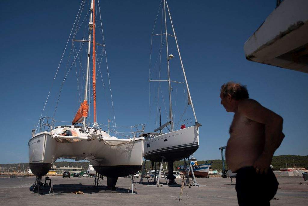 A man watches as another works on a catamaran attacked by killer whales (Orcinus orca) while sailing in the Strait of Gibraltar and taken for repairs at the Pecci Shipyards in Barbate, near Cadiz, southern Spain on May 31, 2023. Groups of killer whales have rammed hundreds of small boats off the coast of Spain in recent years, in "terrifying" behaviour that has baffled scientists. The attacks began in 2020 and they have taken place mainly between Cadiz and the port of Tanger in northern Morocco near the Strait of Gibraltar. So far this year, Spain's coast guard has recorded 28 "interactions" between orcas and sailboats.