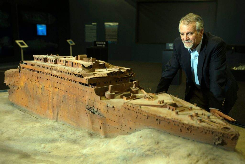 Paul-Henri Nargeolet, director of a deep ocean research project dedicated to the Titanic, poses next to a miniature version of the sunken ship inside a new exhibition, at 'Paris Expo', on May 31, 2013, in Paris.