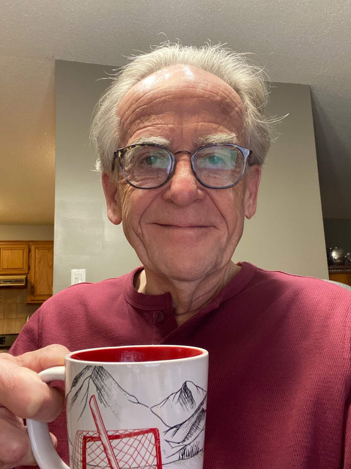 Jim poses with one of his famous coffee mugs, which he features in most Facebook posts.