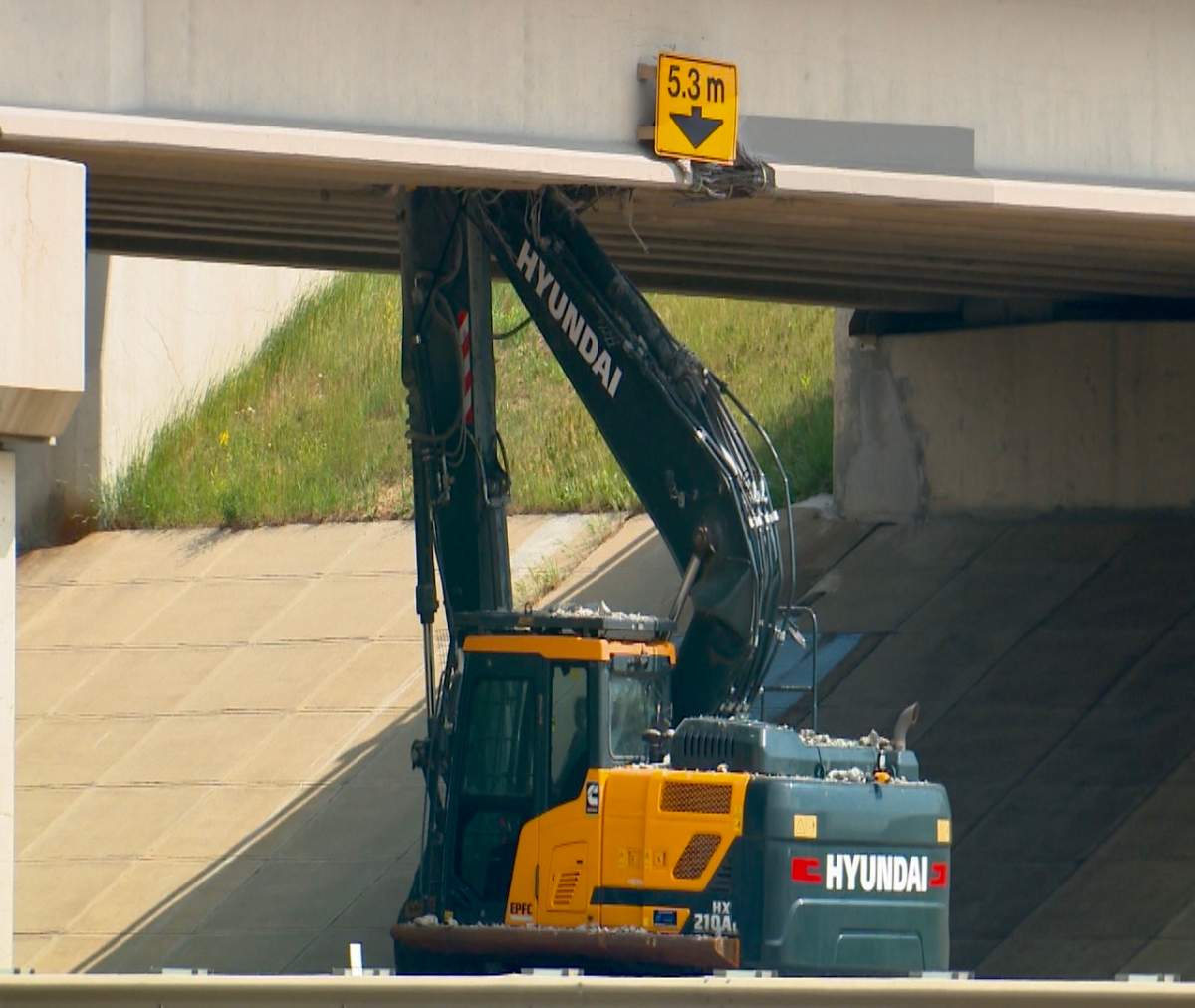 An excavator on a semi trailer collided with overpass bridge deck of Whitemud Drive at Anthony Henday Drive in southeast Edmonton on Friday, June 16, 2023.