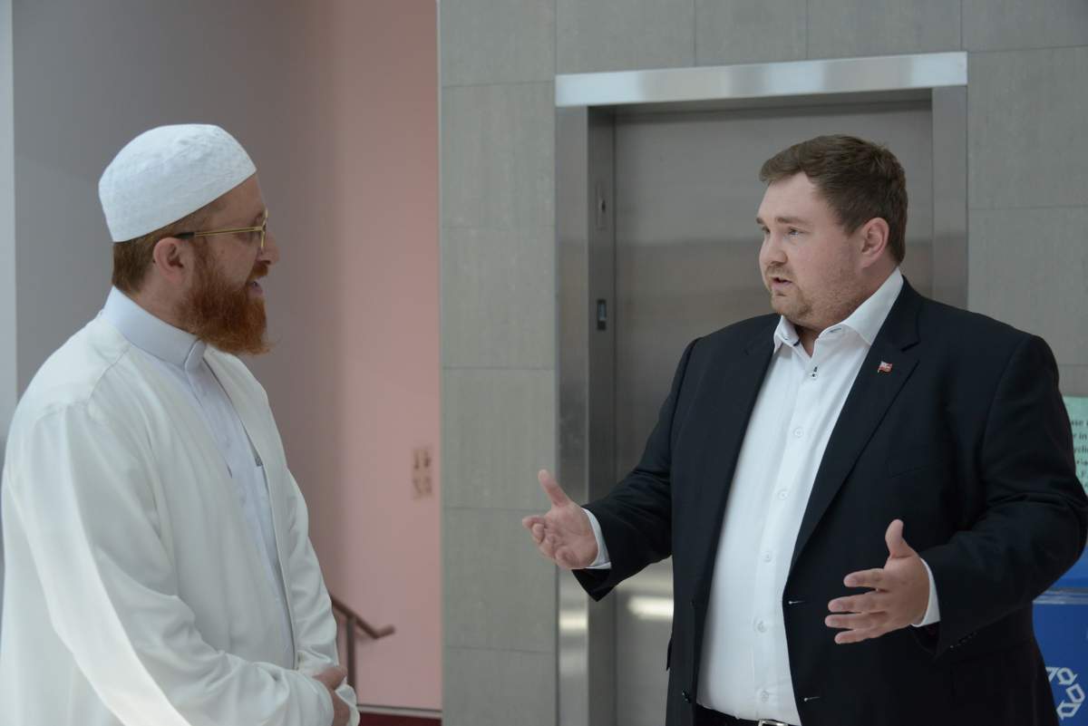 Imam Abd Alfatah Twakkal listens as Minister Michael Ford speaks on June 1, 2023.