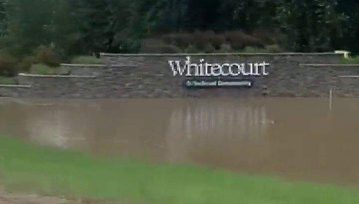 The sign that greets people entering Whitecourt, Alta., is seen on June 20, 2023, the same day the town declared a state of local emergency on because of flooding.