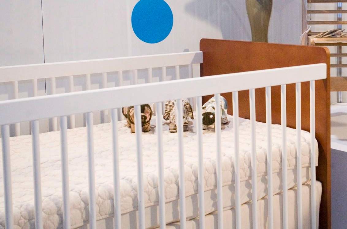 Close-up of a crib with stuffed animals inside.