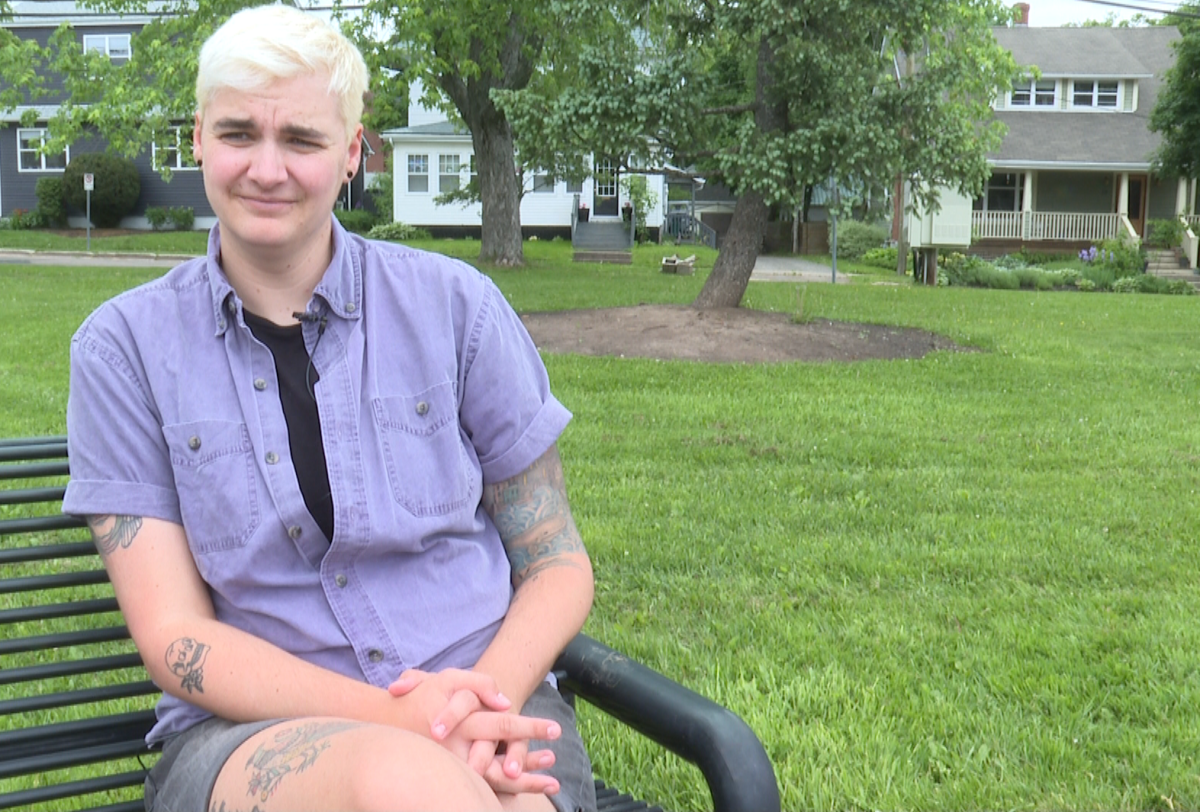 Trans rights activist Dominique Légèr sits on a park bench.