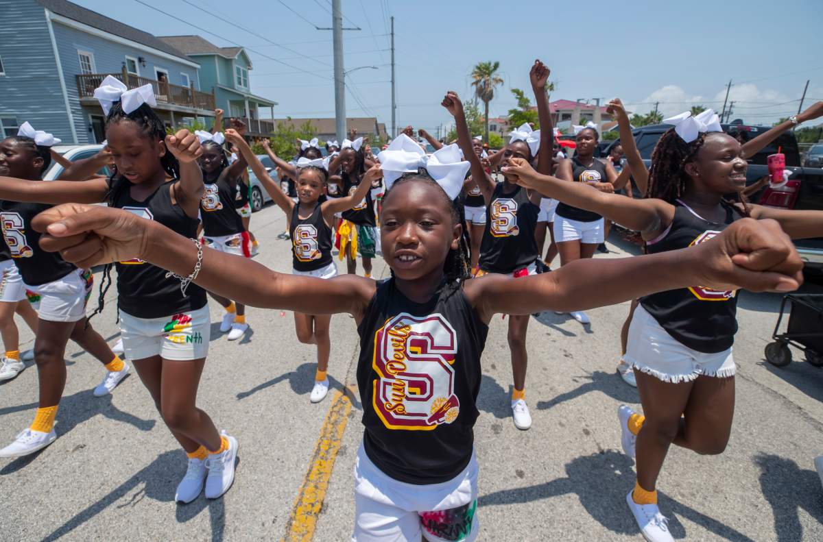 Chrisyah Riddeaux, center, marches along with her fellow cheerleaders in the annual Galveston Juneteenth Parade in Galveston, Texas, on Saturday, June 17, 2023. (Stuart Villanueva/The Galveston County Daily News via AP)