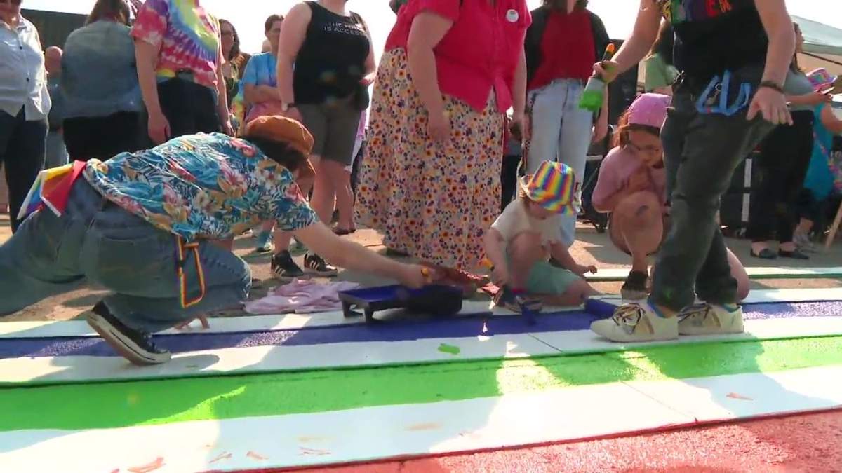 Community members painting a pride crosswalk in Westlock on Tuesday.