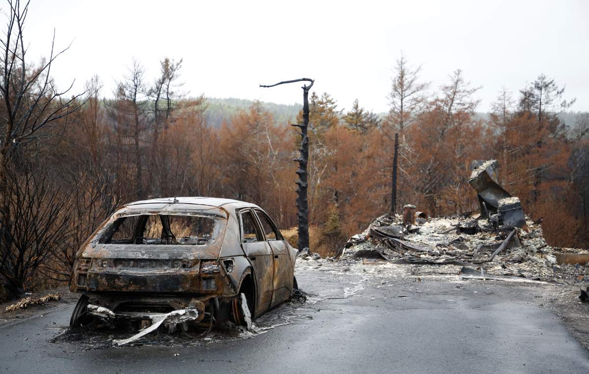 A destroyed car and home are seen on Carmel Crescent following the wildfire in Hammonds Plains, N.S. Tuesday June 6, 2023.