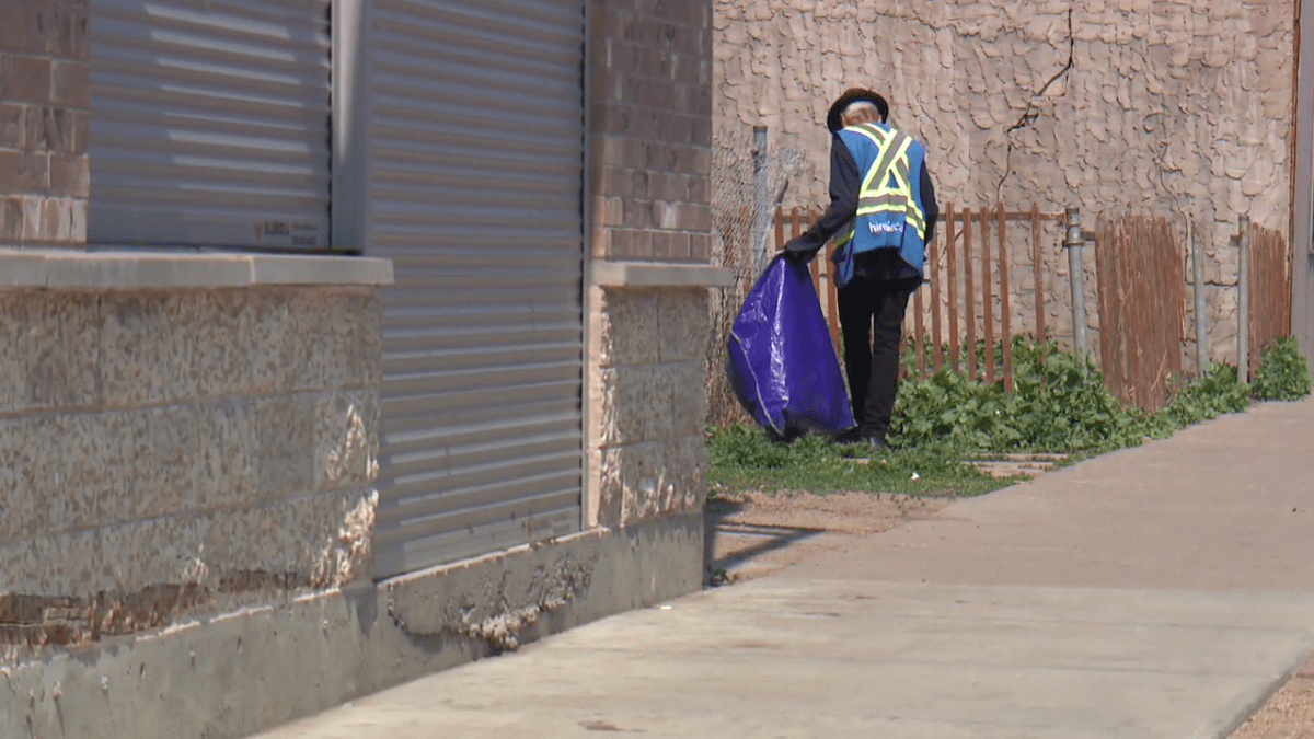 A man cleans up garbage in Edmonton’s Chinatown.