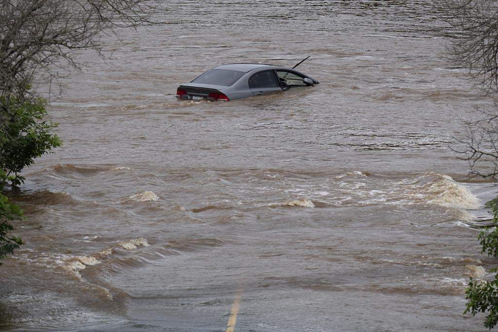 An abandoned car in a mall parking lot is seen in floodwater following a major rain event in Halifax on Saturday, July 22, 2023.