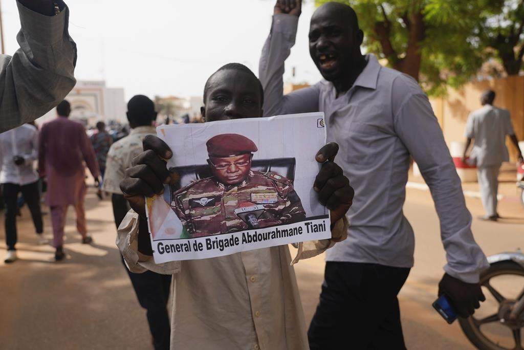 Nigeriens participate in a march called by supporters of coup leader Gen. Abdourahmane Tchiani, pictured, in Niamey, Niger, on  Sunday. Days after after mutinous soldiers ousted Niger’s democratically elected president, uncertainty is mounting about the country’s future and some are calling out the junta’s reasons for seizing control.