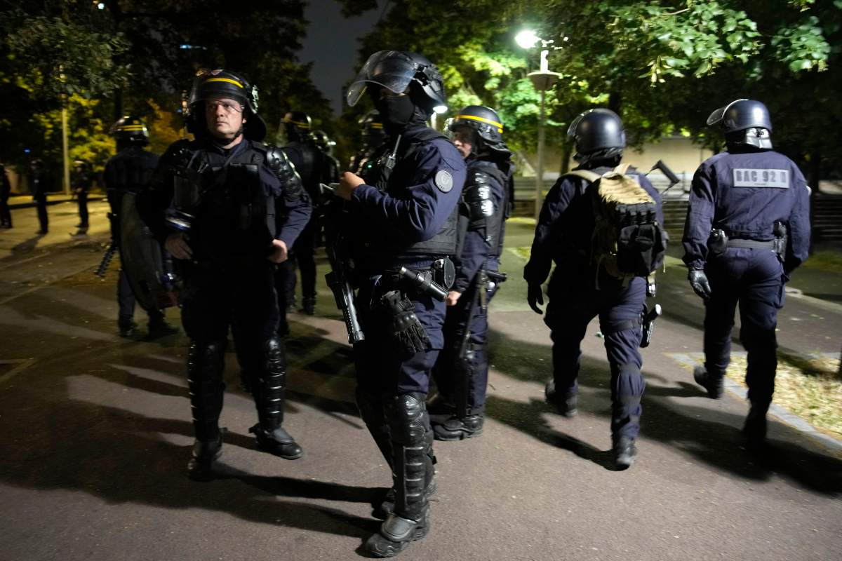 A group of police officers walk during a protest in Nanterre, outside Paris, France, Saturday, July 1, 2023. French President Emmanuel Macron urged parents Friday to keep teenagers at home and proposed restrictions on social media to quell rioting spreading across France over the fatal police shooting of a 17-year-old driver. (AP Photo/Lewis Joly)