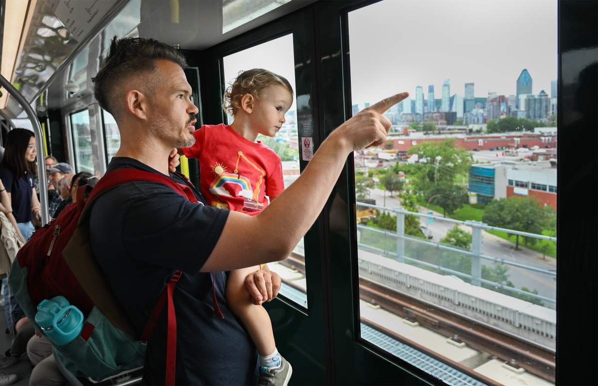 Alex Busby and son Oscar take a ride on the Reseau express metropolitain (REM) light rail system in Montreal, Saturday, July 29, 2023. The REM opens Monday to fare paying passengers.