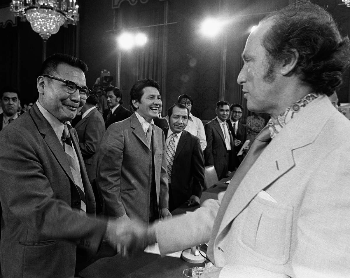 A black and white photo of two men shaking hands.