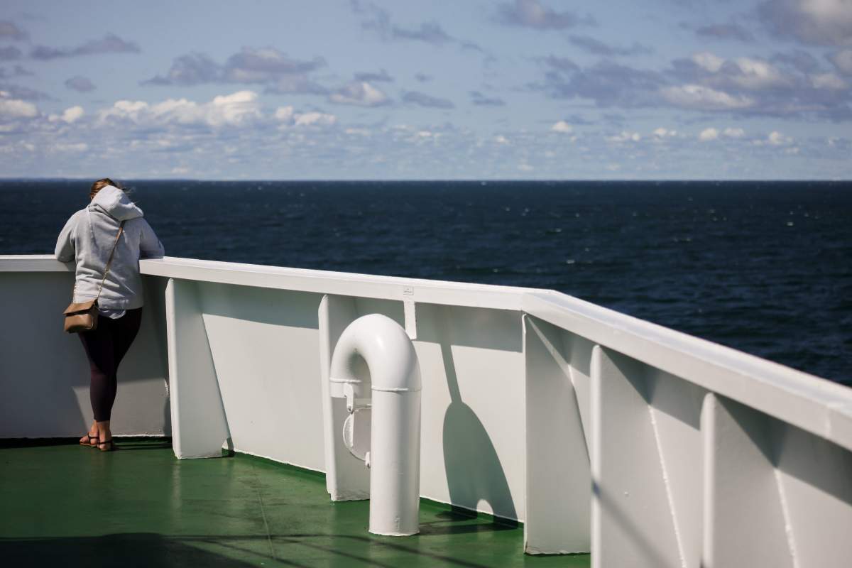 A woman checks her smartphone while aboard the MV Confederation ferry as it crosses the Northumberland Straight between Prince Edward Island and Nova Scotia on August 26, 2017. 