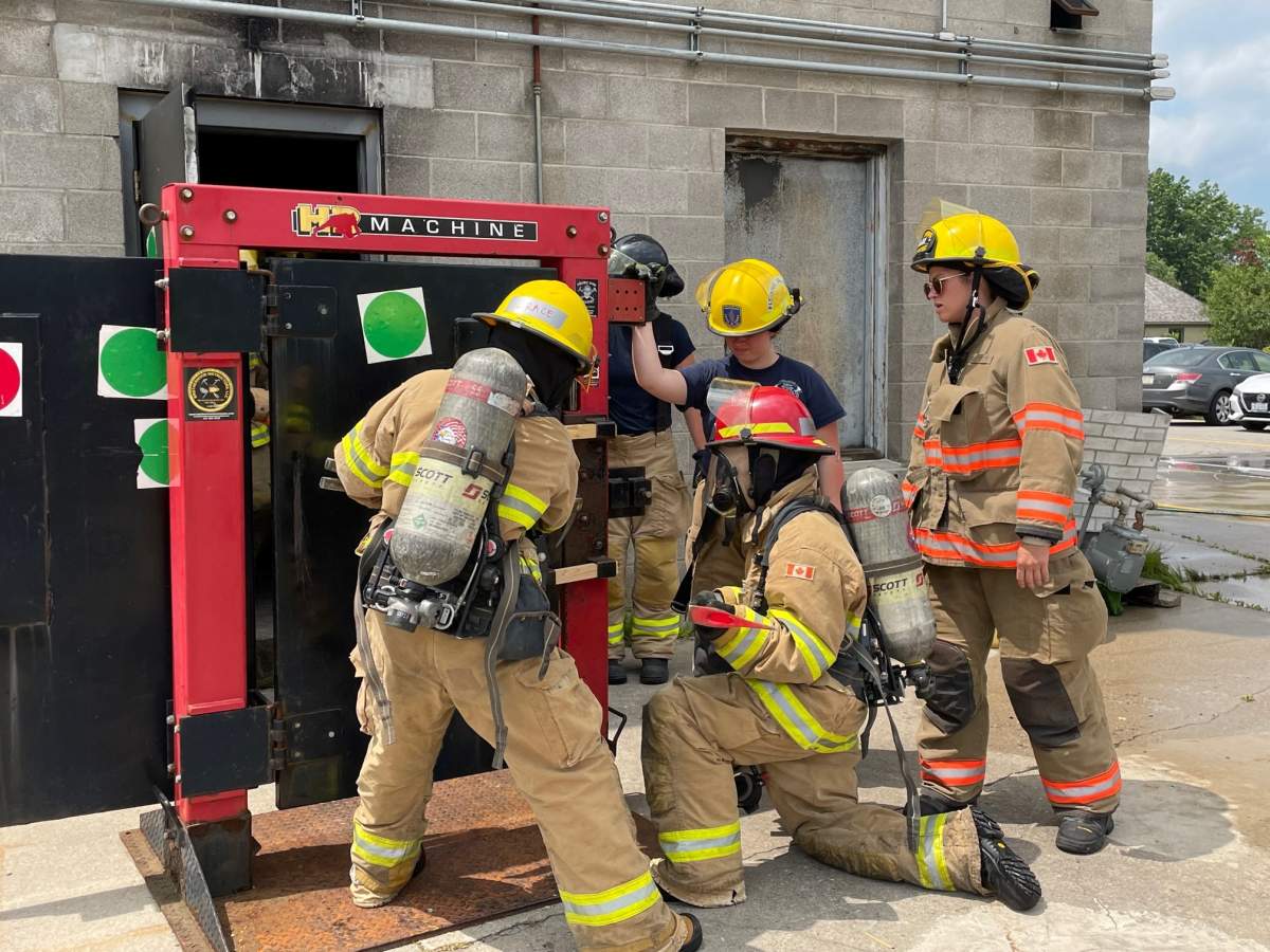 Camp Future Firefighters in Training participants Grace Cullen and Grace Carter work to break open a door at Fire Station 9 on July 20, 2023.