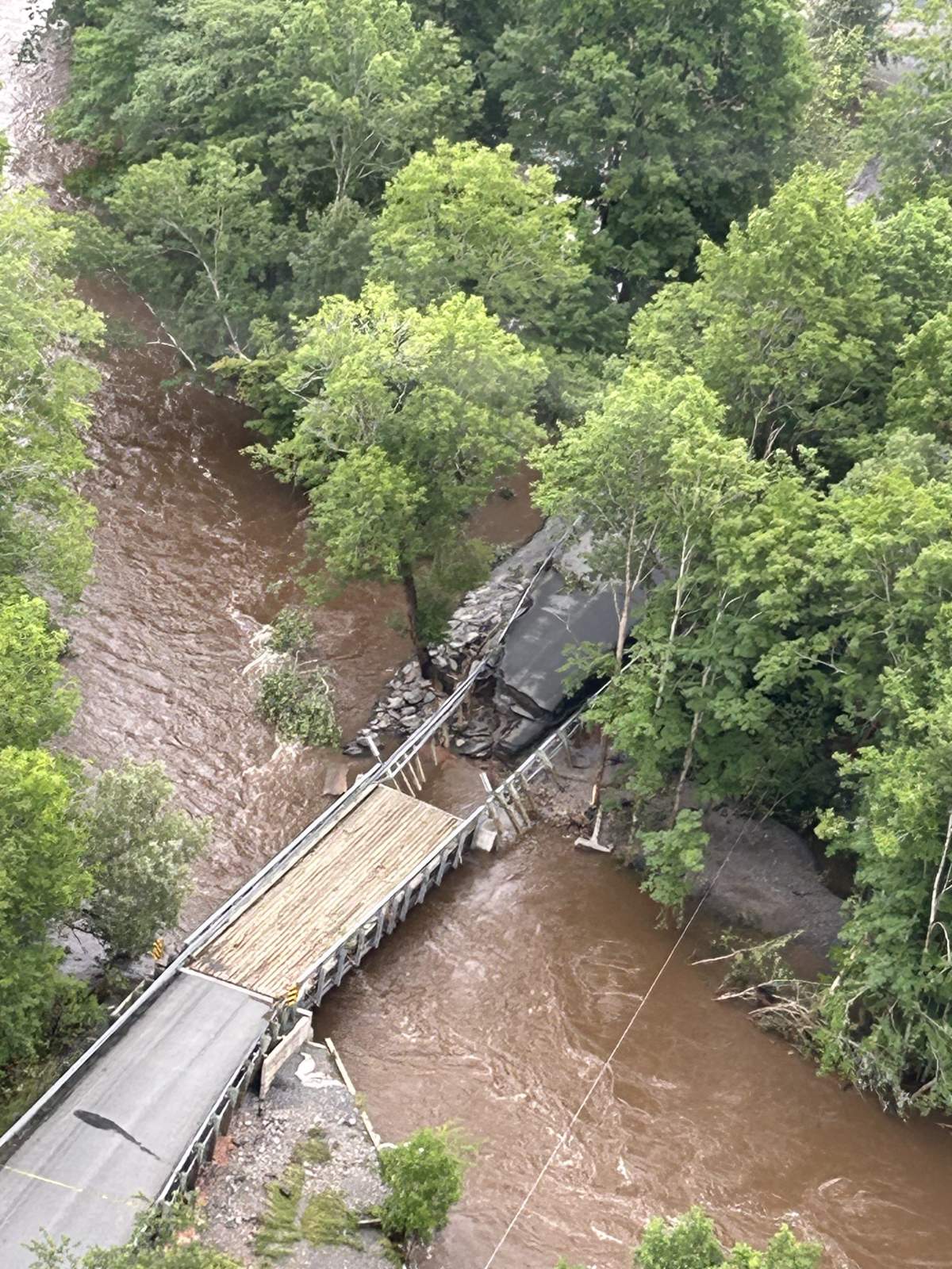 An aerial shot of a bridge that's been heavily damaged by flood water near Smileys Provincial Park in Newport, Hants County.