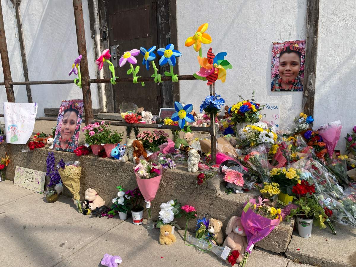 Posters, flowers, stuffed animals and other keepsakes left along a sidewalk and staircase in St. Thomas, Ont.
