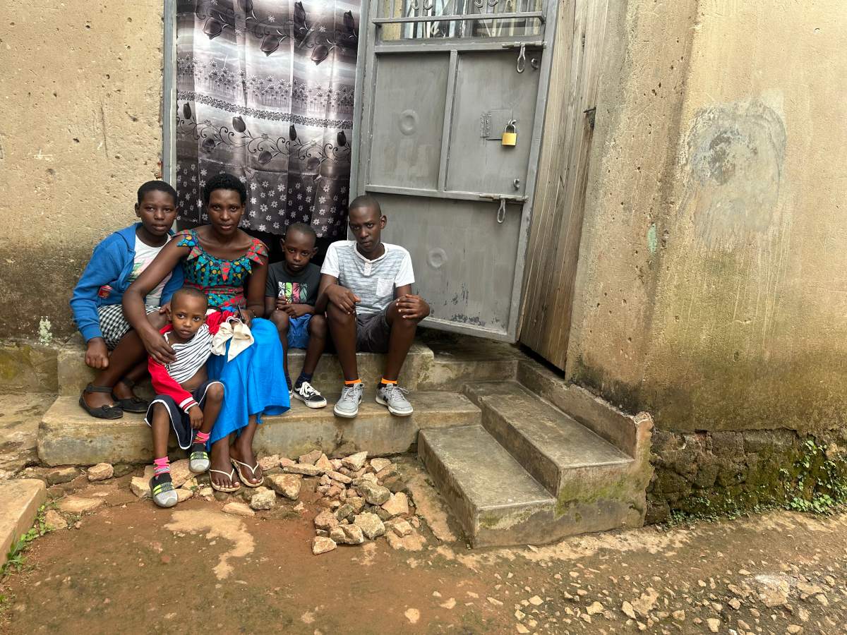 Jolie Mutirabura and her four children on the steps of their new home in Uganda after fleeing DRC.