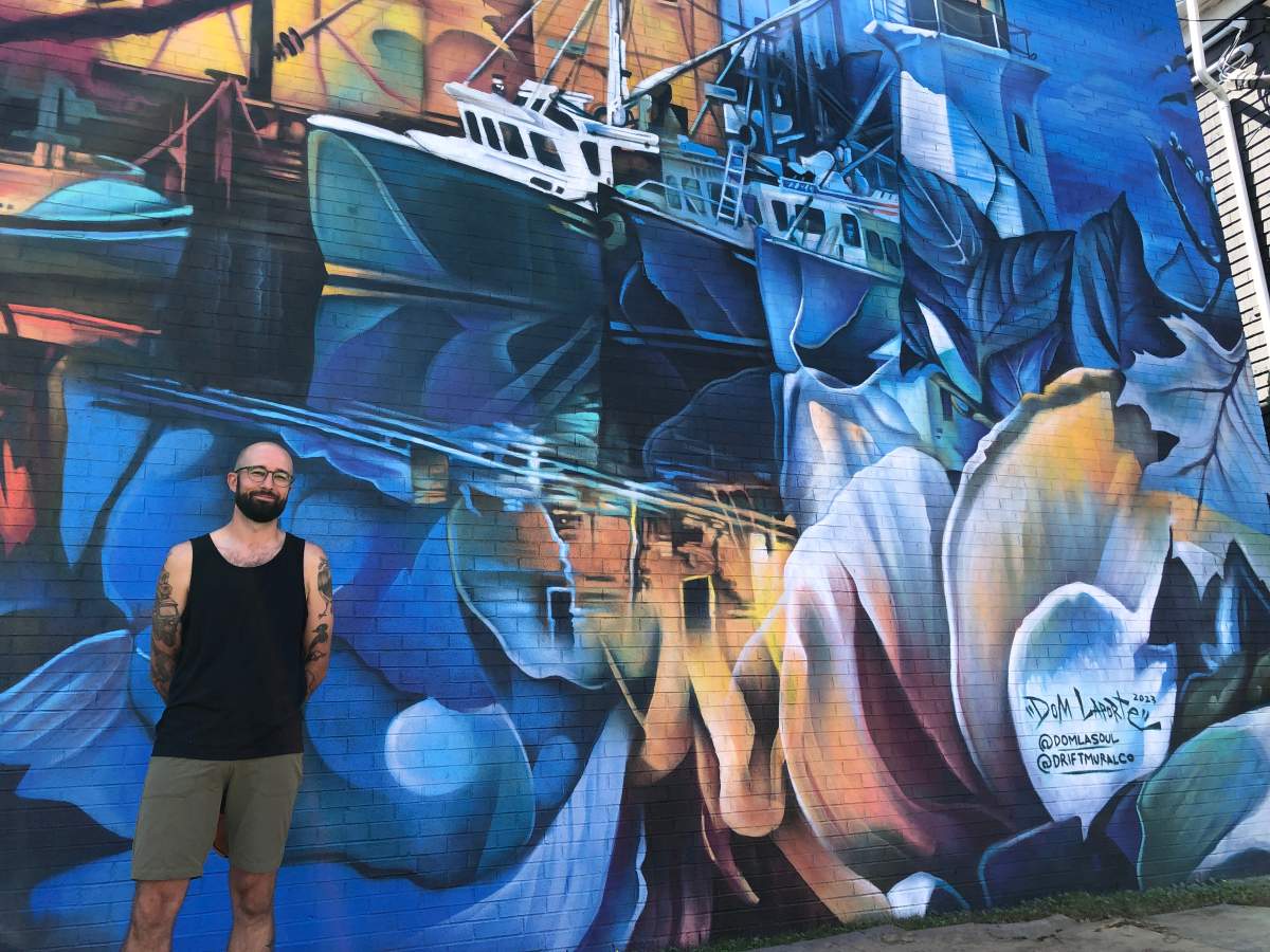Artist Dominic Laporte of Drift Mural Co. stands in front of his work along Quinpool Road as part of the Halifax Mural Festival.