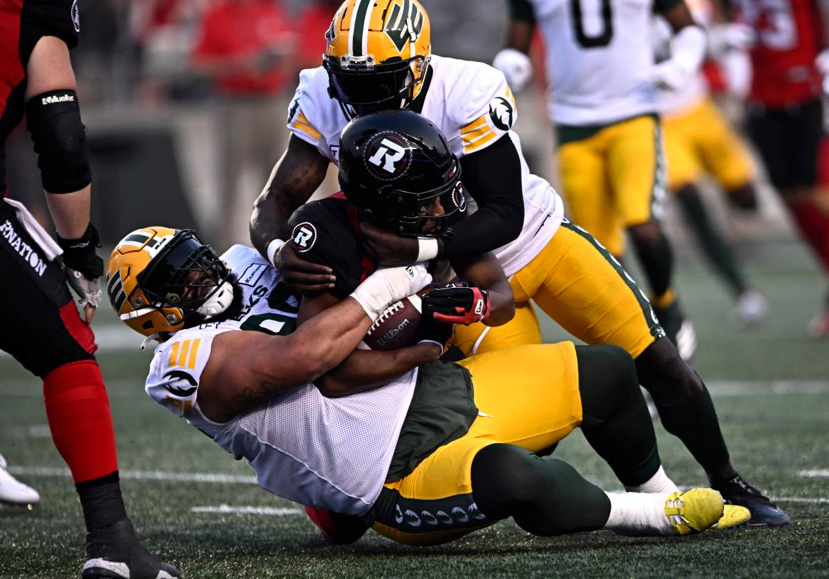 Elks defensive lineman J-Min makes a tackle on Redblacks running back De'Montre Tuggle.