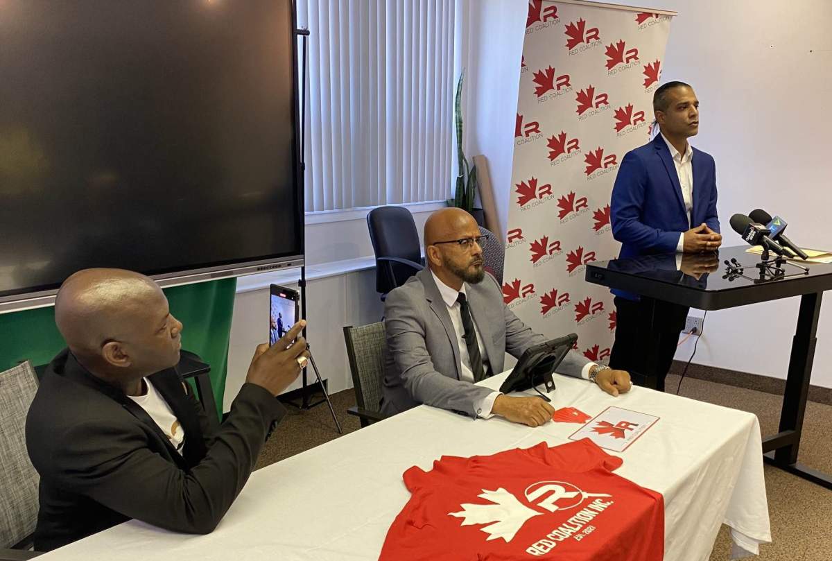 Iman Niknam (far right) speaks to reporters at a press conference in Montreal alongside Red Coalition founder and executive director Joel DeBellefeuille (left) and director on issues of racial profiling and public safety Alain Babineau (centre). July 26, 2023.