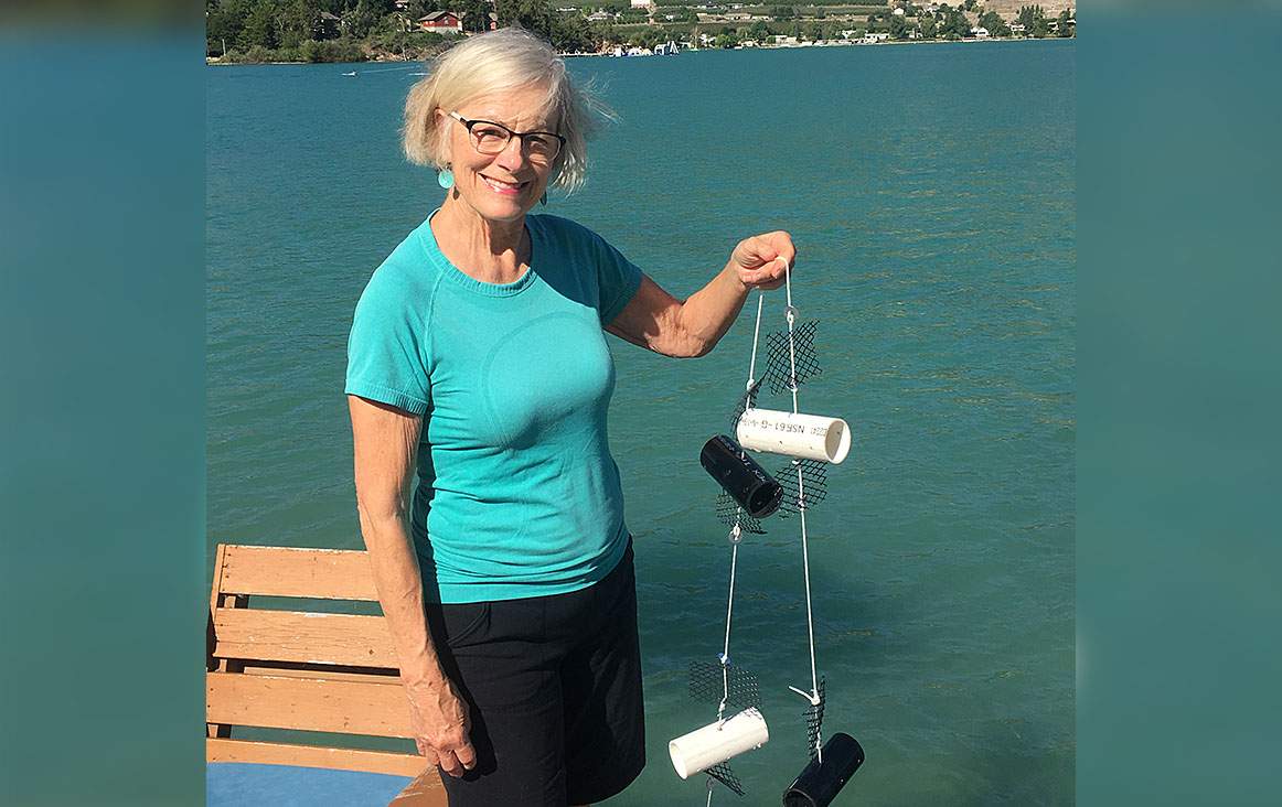File photo of an OASISS volunteer holding an invasive mussel monitor.