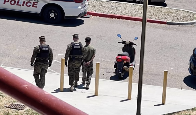 Photo of an unidentified Marine being led away in handcuffs at Camp Pendleton on June 28, 2023.