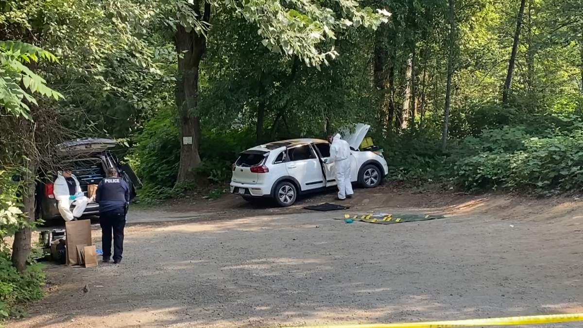 Police process the scene where a white Kia Niro was found on fire on Murray Street in Port Moody, B.C. on Wed. July 5, 2023. A white Kia Niro was identified as a the suspect vehicle in a homicide in Coquitlam, B.C. on July 2, 2023.