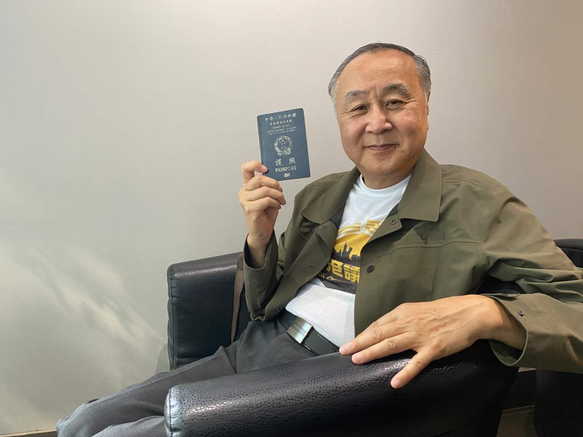 Hong Kong democracy activist Elmer Yuen shows his Hong Kong passport during an interview in Vancouver on Wednesday, July 5, 2023. The Hong Kong government has offered a $170,000 reward for Yuen’s arrest, accusing him of national security offences.THE CANADIAN PRESS/Nono Shen