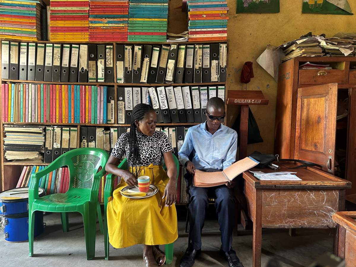 Isabella Ajio sits beside a teacher with a visual impairment who instructs special needs children.