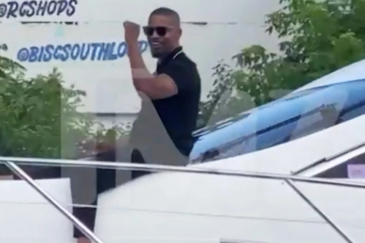 Jamie Foxx waves to fans from a boat in Chicago.