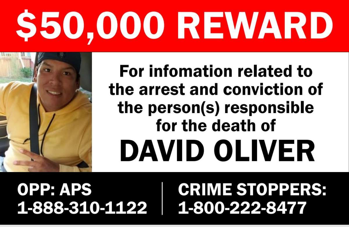 A poster with a picture of a man in a yellow sweater on the left and writing on the side asking for tips to be sent to police.