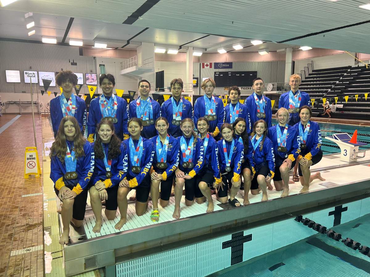 A group of swimmers pose with their medals