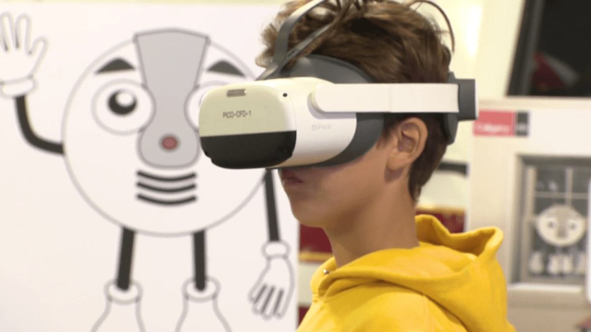 Brody Quinn tries out the Calgary Fire Department's VR fire safety program on July 27, 2023, with a picture of a smoke detector character behind him.