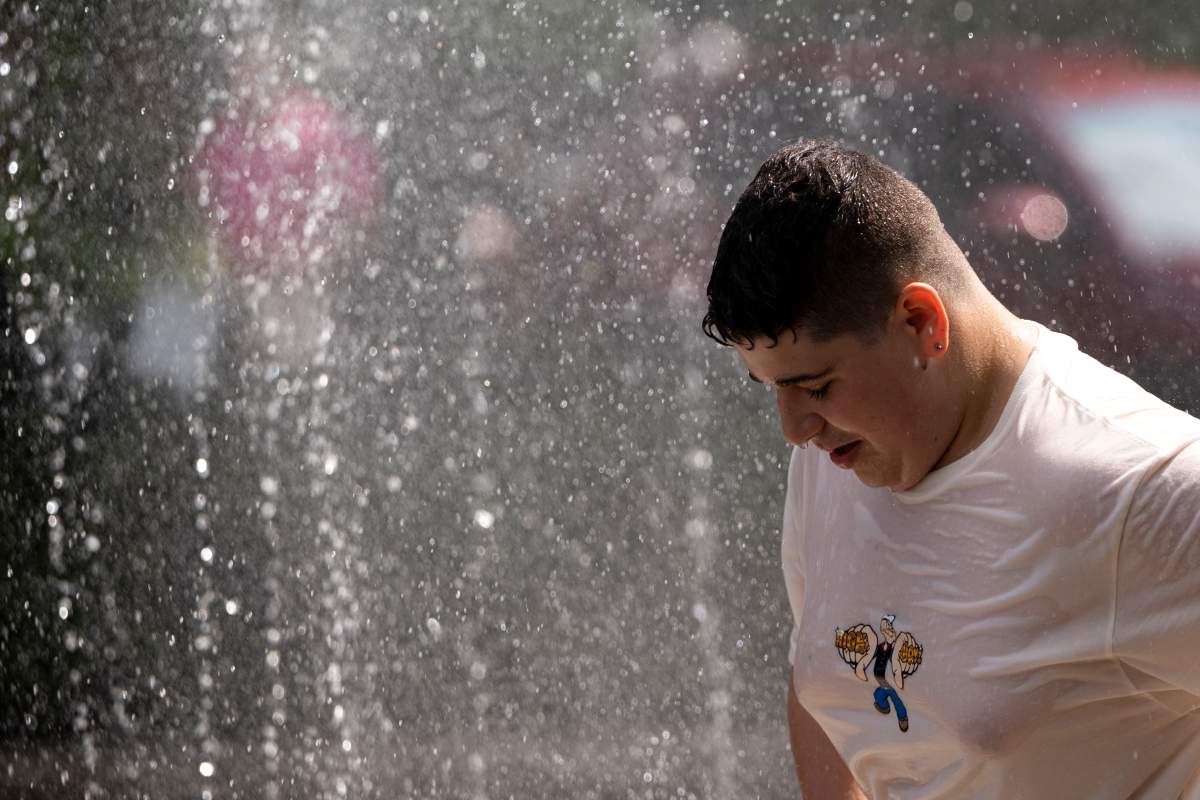 A person cools off in a water fountain on the Halifax Waterfront in Halifax on Thursday, July 6, 2023. A heat warning was issued for all Maritime provinces with soaring temperatures and high humidity across the region. THE CANADIAN PRESS/Darren Calabrese