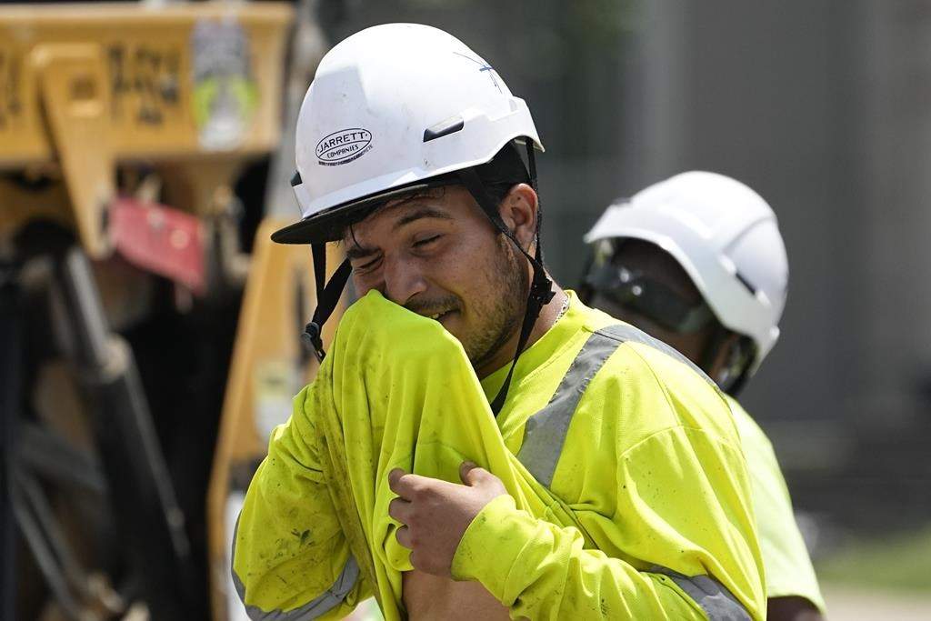 Ontario is proposing regulations to limit heat-related illnesses in workplaces amid the rise of extreme heat events across Canada. A construction worker wipes his face as he works in the heat, Friday, June 30, 2023, in Nashville, Tenn. 