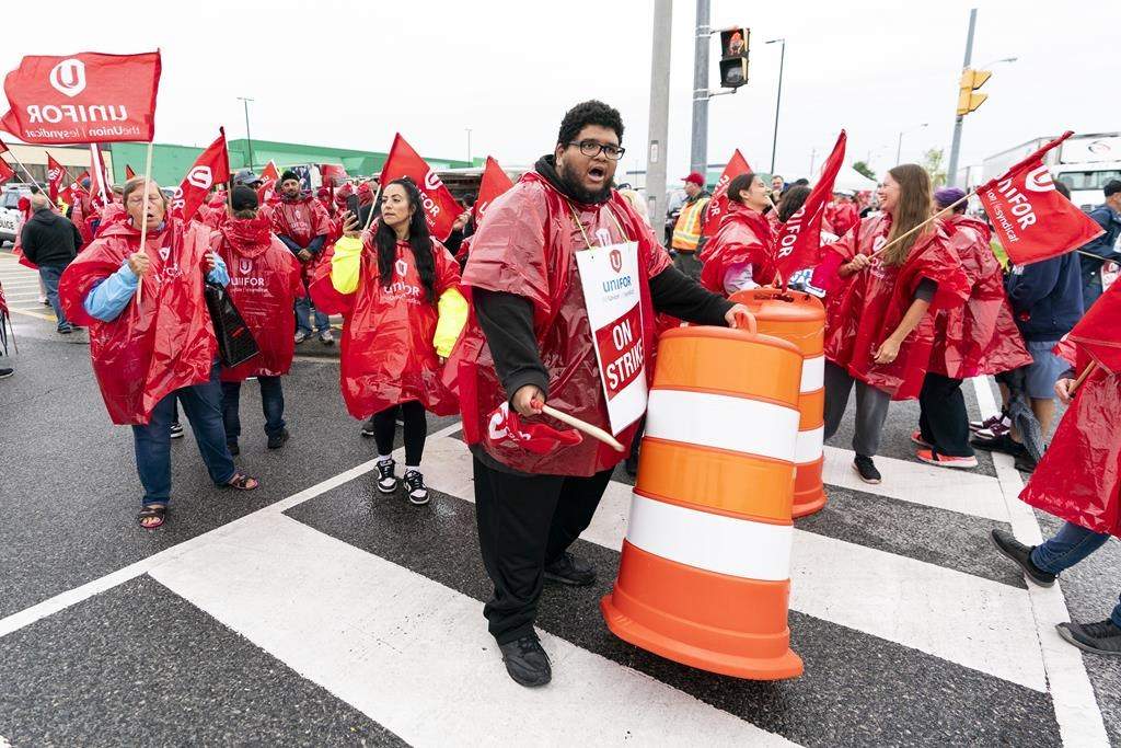A striking employee of the grocery store Metro drums using a construction cone at the secondary picket line at a distribution warehouse in Toronto, Wednesday, Aug. 23, 2023.by.