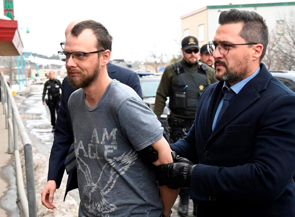 Steeve Gagnon is escorted by police into court in Amqui, Que., Tuesday, March 14, 2023. A preliminary hearing for a Quebec man charged with killing three people with his truck has been postponed until January 2024. A spokesperson for the province's director of criminal and penal prosecutions says the request was made by Steeve Gagnon's lawyer on Tuesday. Gagnon, 38, is charged with three counts of first-degree murder and nine counts of attempted murder in connection with the March 13 incident in Amqui, Que., about 350 kilometres northeast of Quebec City. THE CANADIAN PRESS/Jacques Boissinot.