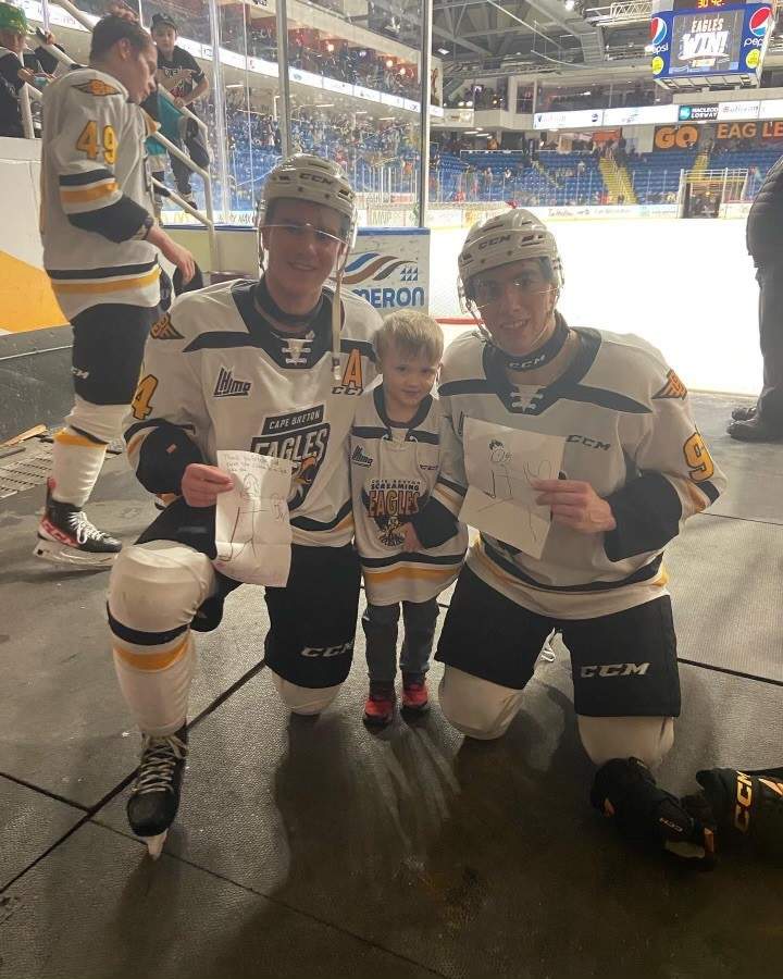 Avery Pynn, 5, poses with his two favourite Cape Breton Eagles players: Brayden Schmitt and Jacob Newcombe.