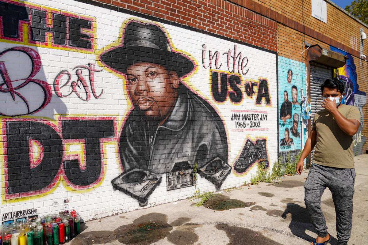 FILE - A pedestrian passes a mural of rap pioneer Jam Master Jay of Run-DMC, by artist Art1Airbrush, Aug. 18, 2020, in the Queens borough of New York.