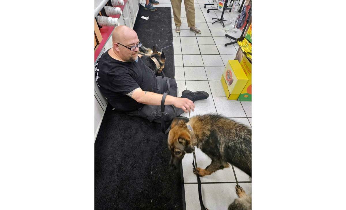 In this photo provided by the Humane Society of Hobart, Ind., a dog suffering from heat-related injury is aided by a man inside the Road Ranger convenience store, in Lake Station, Ind., July 27, 2023.