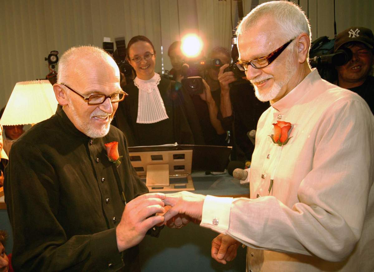Roger Thibault (left) places a wedding band on Theo Wouters during their wedding at the Montreal Courthouse on Thursday July 18, 2002. They were the first same-sex couple to be legally joined in a civil union in North America.