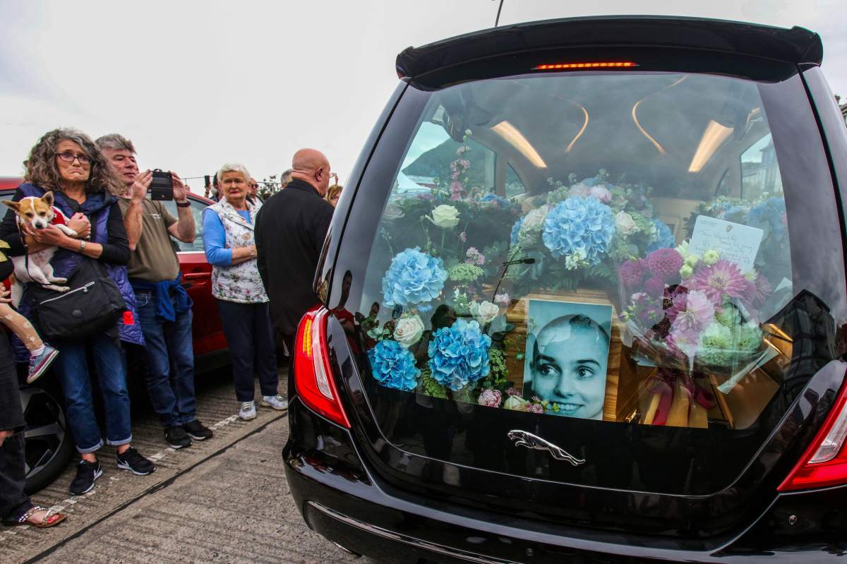 O'Connor's casket is seen in the hearse, surrounded by flowers and her photo.