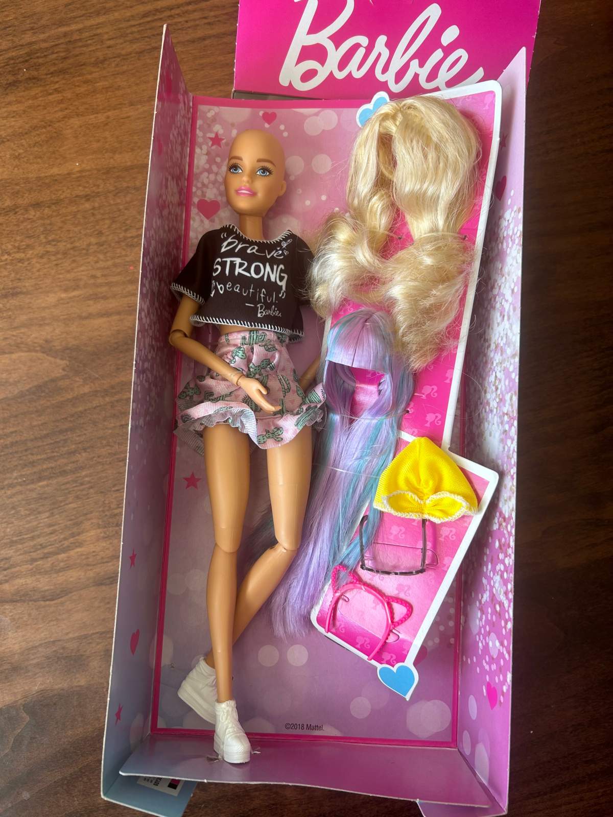 Families with cancer can apply to for a Brave Barbie, who has a bald head and comes with fun wigs and accessories.