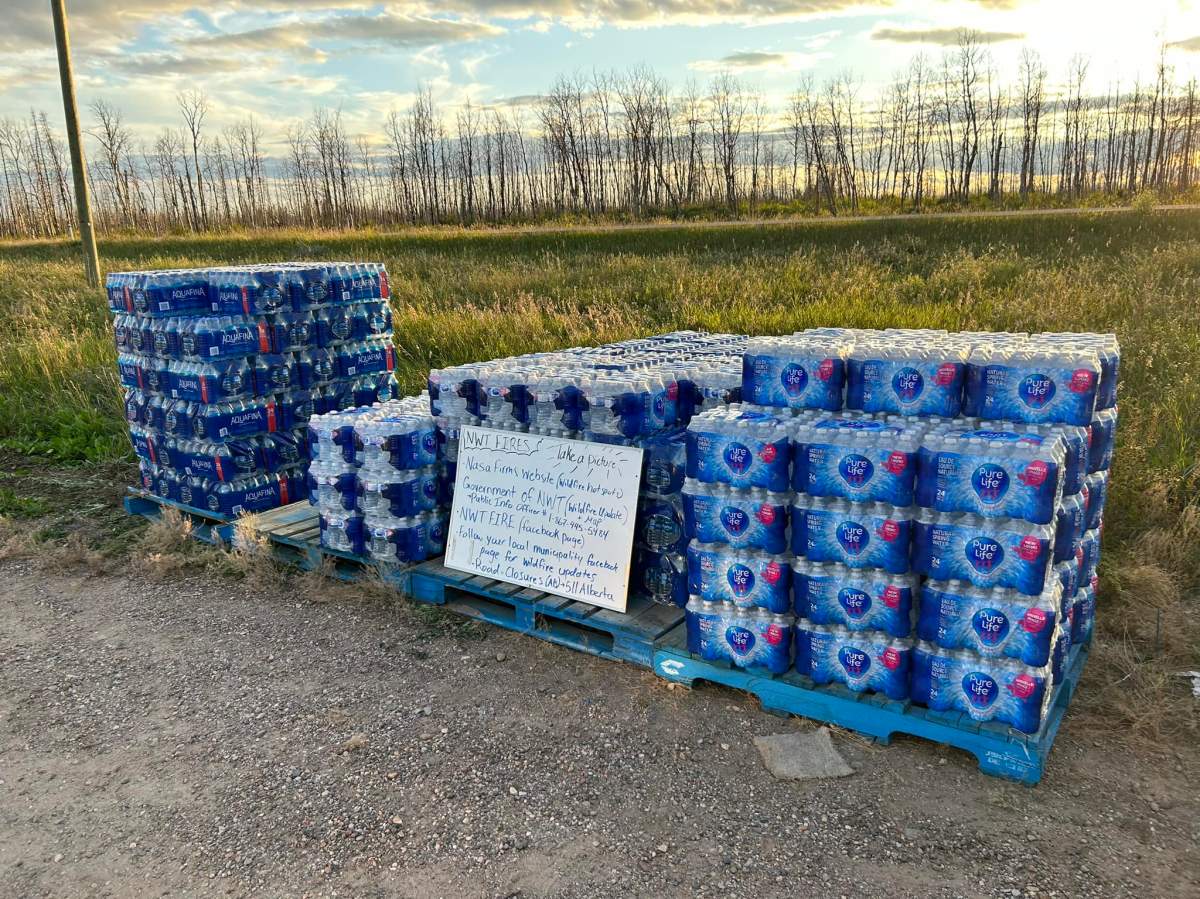 Alberta Wildfire officials and a fuel truck from Petro Canada greeting Northwest Territories evacuees, providing fuel and bottled waters as they enter the province near Steen River on Thursday, August 17, 2023.